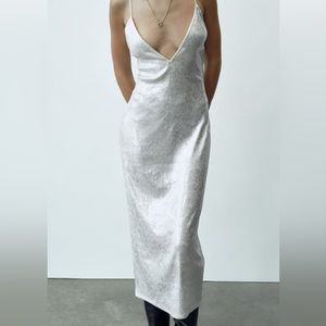 V-neck midi dress with thin straps. Back slit. Sequin appliqué.